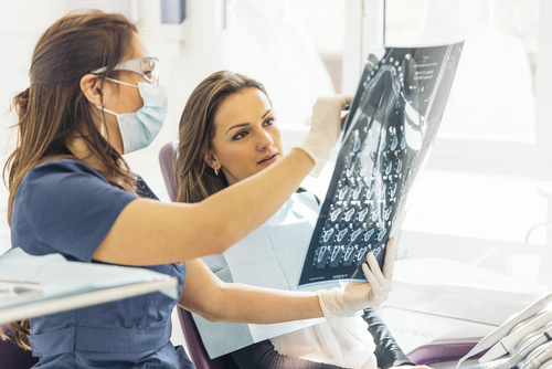 dentist goes over x-ray with patient